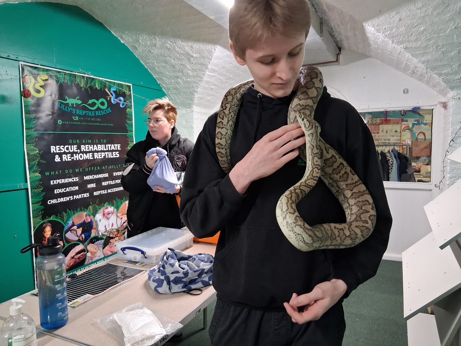 A young visitor holding a snake at a community event